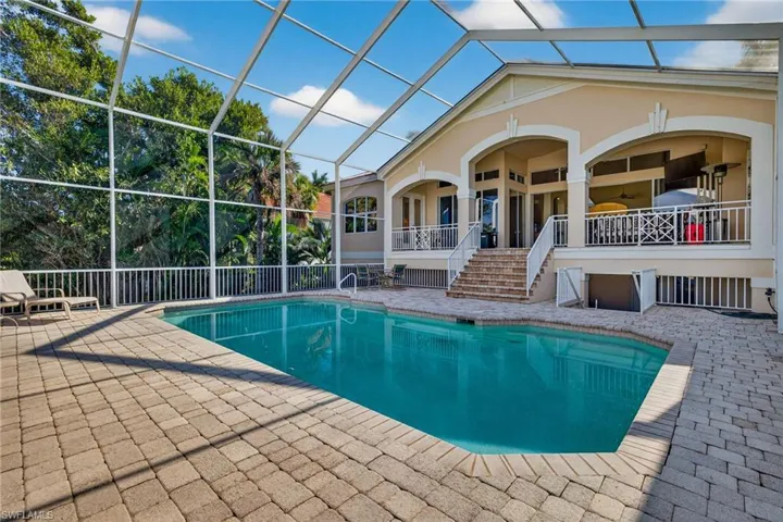 Swimming pool featuring a patio, a lanai, a sunroom, and stairs