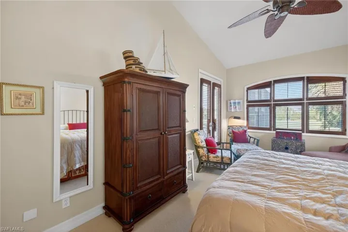 Bedroom featuring light colored carpet, ceiling fan, and lofted ceiling