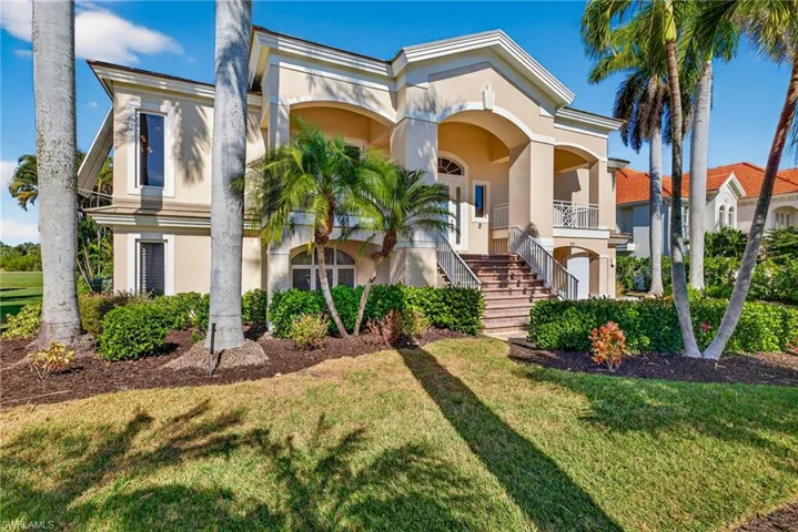 View of front of home featuring stairs, stucco siding, a front yard, and a balcony