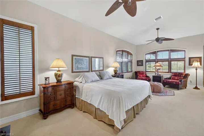 Primary bedroom with ceiling fan and lofted ceiling