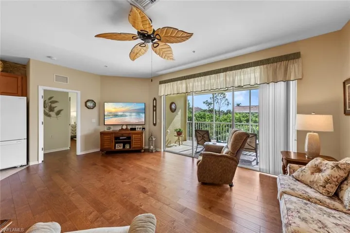 Living room with ceiling fan and dark hardwood / wood-style flooring