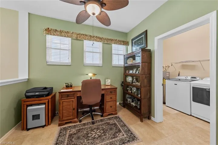 Office space with washing machine and clothes dryer and ceiling fan