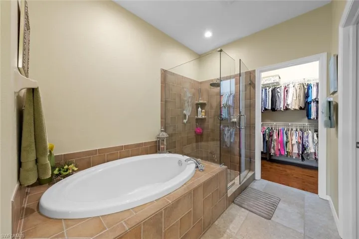 Bathroom featuring independent shower and bath and tile patterned flooring