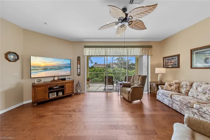 Living room with ceiling fan and dark hardwood / wood-style floors