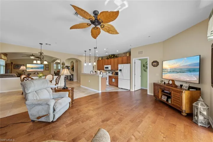 Living room with ceiling fan, light hardwood / wood-style floors, and sink