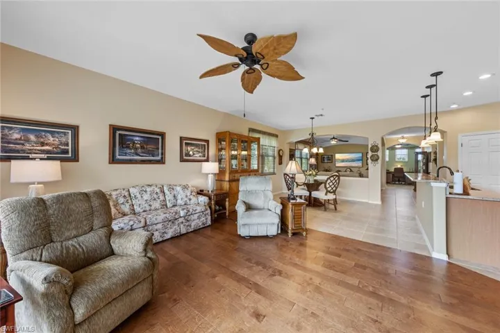 Living room with ceiling fan, light hardwood / wood-style floors, and sink