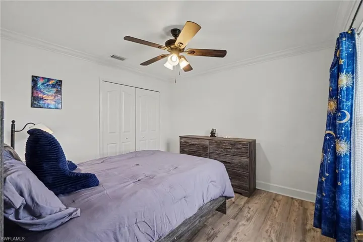 Wood-finish flooring, ceiling fan with integrated lighting, and dual-panel closet doors
