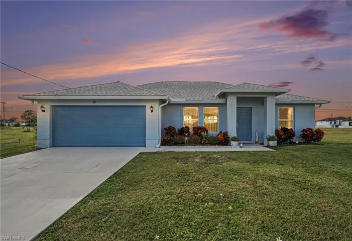 Single-story residence featuring a smooth stucco exterior, attached two-car garage, concrete driveway, and covered entryway