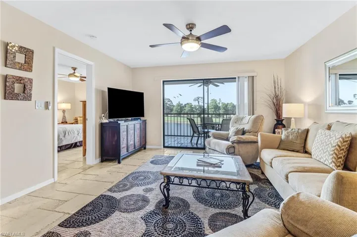 Living room featuring ceiling fan and light tile floors
