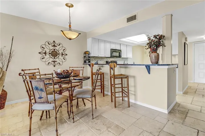 Dining room with a skylight and light tile floors