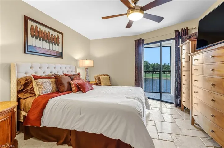 Tiled bedroom with ceiling fan and access to exterior
