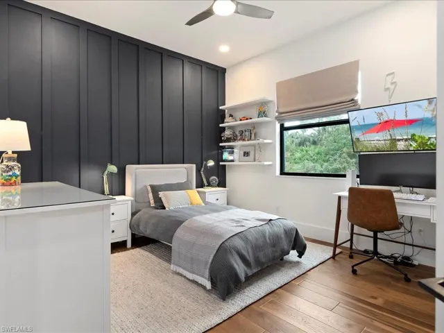 The second bedroom has board & batten walls, a ceiling fan, room darkening shades, and a custom PLC closet system.