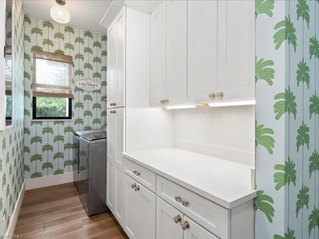 Who wouldn't enjoy laundry in this room? You'll love the fun palm tree wallpaper in addition to the new cabinets, whimsical light fixture, and tile backsplash.