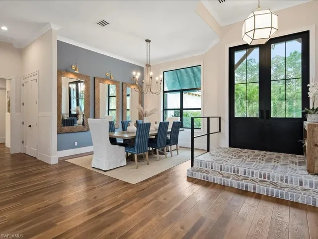 The interior of the foyer was also structurally reconfigured to open up the dining room. In the process, the beautiful brick entryway was added along with the custom iron rail.
