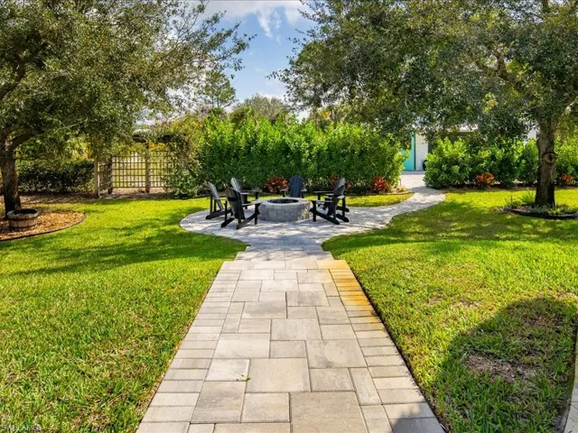 A few steps down from the pool and chickee hut is the built-in firepit with paver surround.