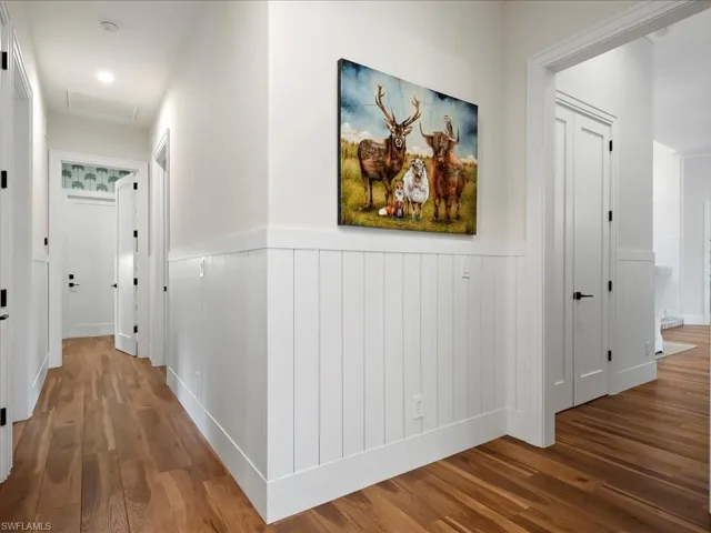 Heading back into the house, the opposite side is where you'll find three more bedrooms, two full bathrooms, the laundry room, and garage access.
