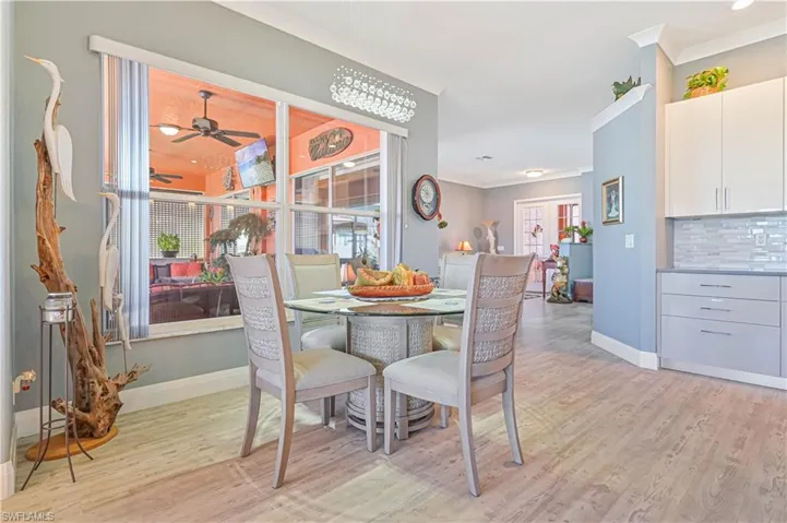 Dining room featuring crown molding, baseboards, light wood-style floors, and a ceiling fan