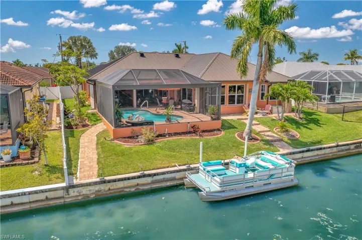 Rear view of house featuring a patio, a water view, an outdoor pool, and glass enclosure