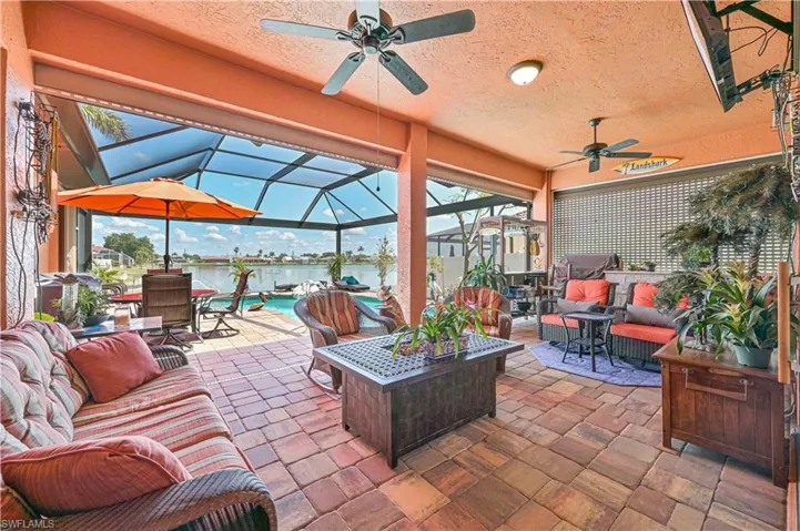 View of patio / terrace featuring outdoor lounge area, outdoor dining area, a water view, a ceiling fan, and glass enclosure