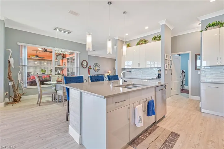 Kitchen with a sink, light countertops, tasteful backsplash, and dishwasher