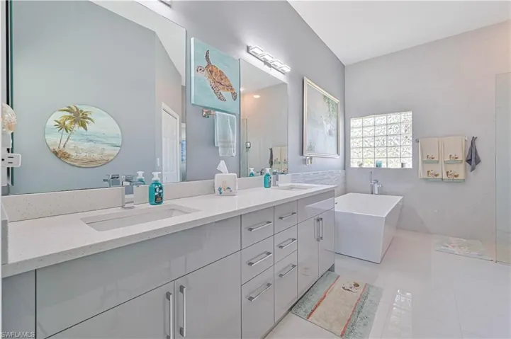 Bathroom featuring a sink, a soaking tub, and double vanity