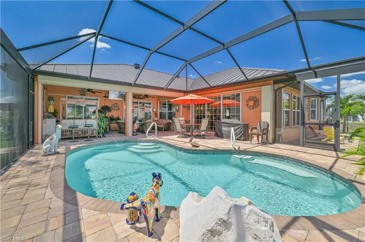 Pool featuring glass enclosure, ceiling fan, and a patio area