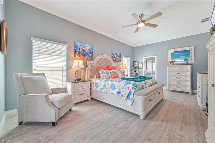 Bedroom featuring visible vents, light wood finished floors, ceiling fan, and baseboards