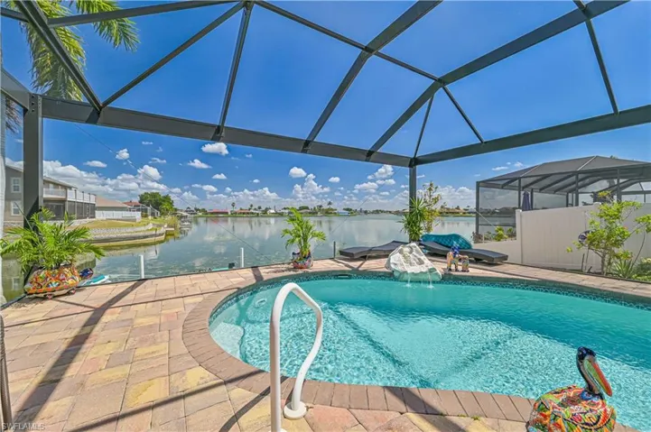 View of pool featuring a fenced in pool, a water view, glass enclosure, and a patio