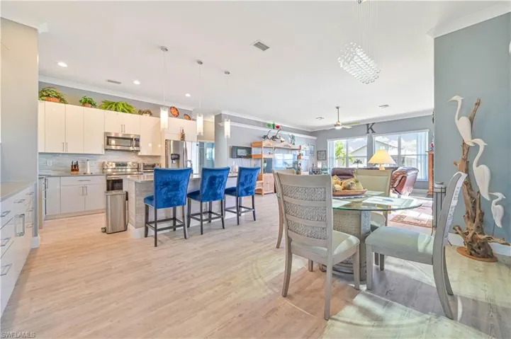Dining space with visible vents, ornamental molding, light wood-style flooring, and recessed lighting