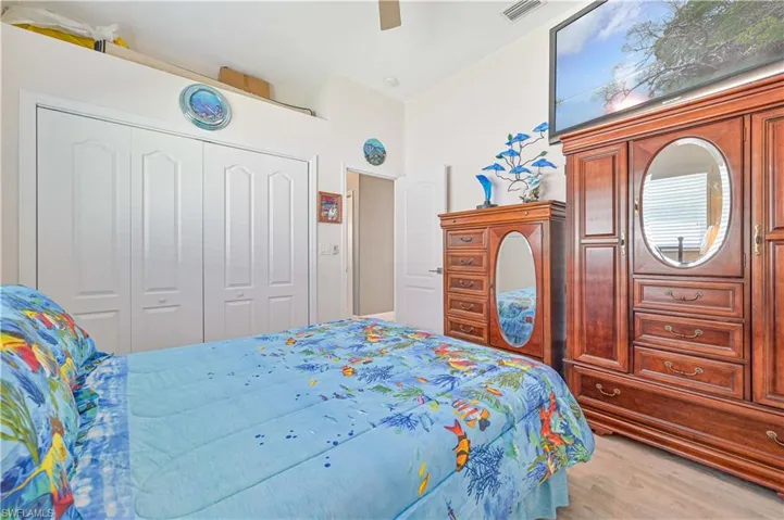 Bedroom featuring visible vents, a ceiling fan, light wood-style flooring, and a closet