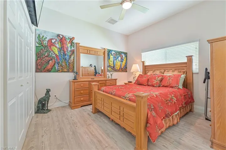 Bedroom featuring light wood-style floors, a ceiling fan, and visible vents