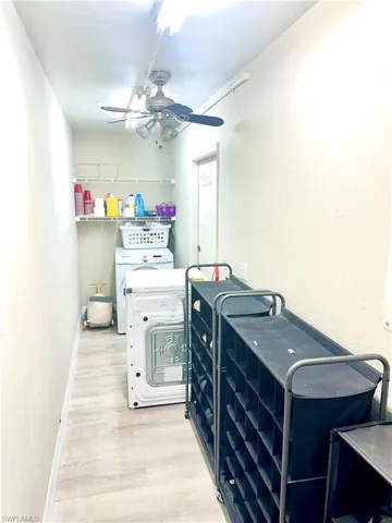 Utility room featuring wood-finish flooring, overhead track lighting, and a ceiling fan