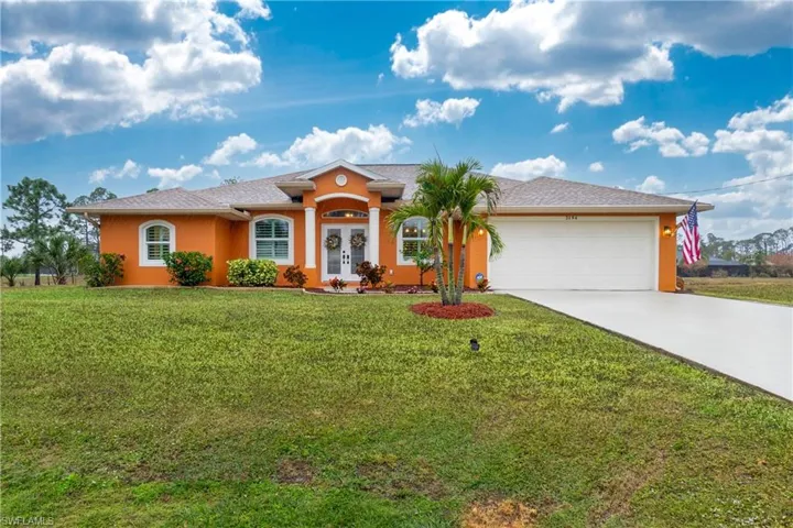 Ranch-style home featuring a garage and a front lawn