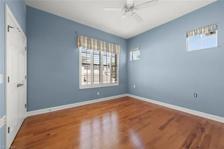 Guest Bedroom with wood finished floors, baseboards, and ceiling fan