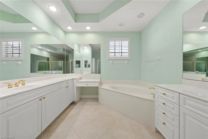 Primary bathroom with dual sinks and separate tub.
