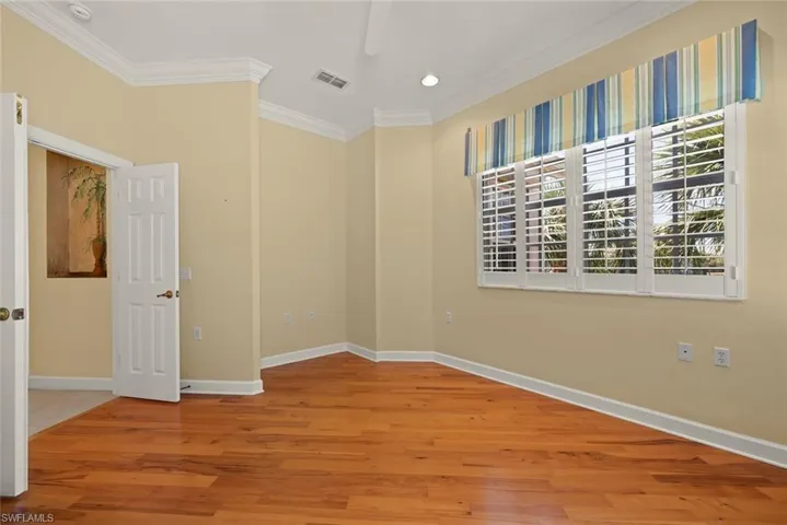 Den with a wealth of natural light, ceiling fan, baseboards, and crown molding