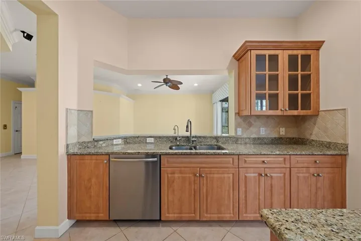 Kitchen featuring Bosh dishwasher, granite countertops and tile floors.