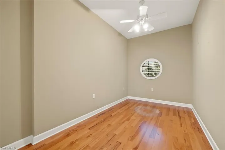 Spare room perfect for an office or exercise room featuring ceiling fan, light wood-type flooring, and baseboards.