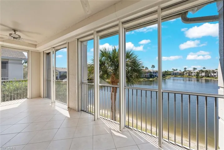 Screened lanai featuring a ceiling fan, a water view, and a wealth of natural light