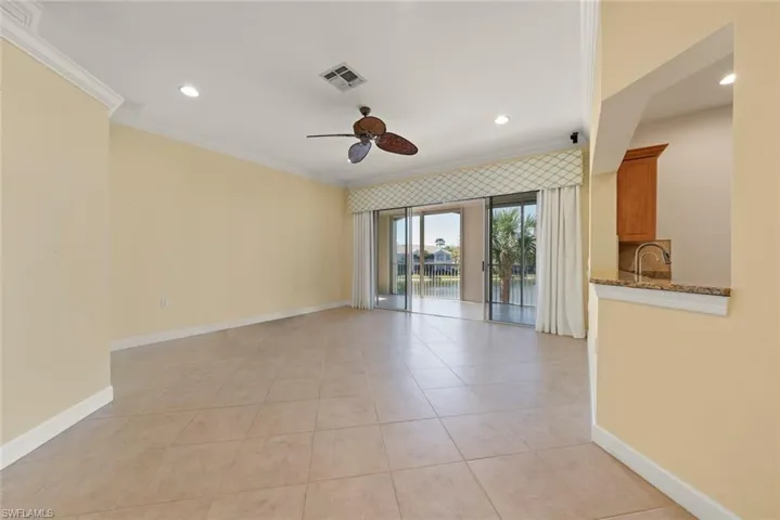 Open living area with tile floors and crown molding