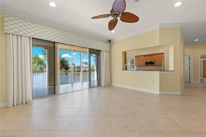 Open living area with tile floors and crown molding with a view of the water.