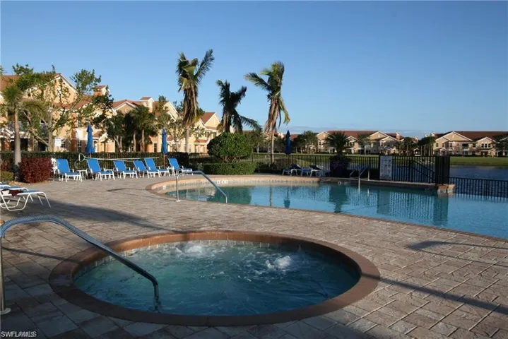 View of swimming pool featuring a community hot tub and a patio