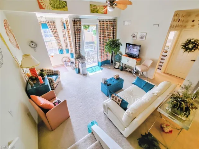 Carpeted living room featuring ceiling fan