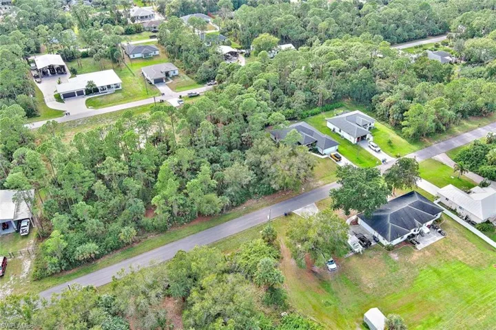 Aerial view of property and surrounding area with nearby suburban area