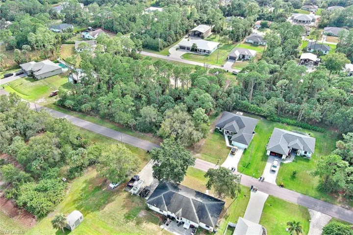Aerial view of property and surrounding area with nearby suburban area