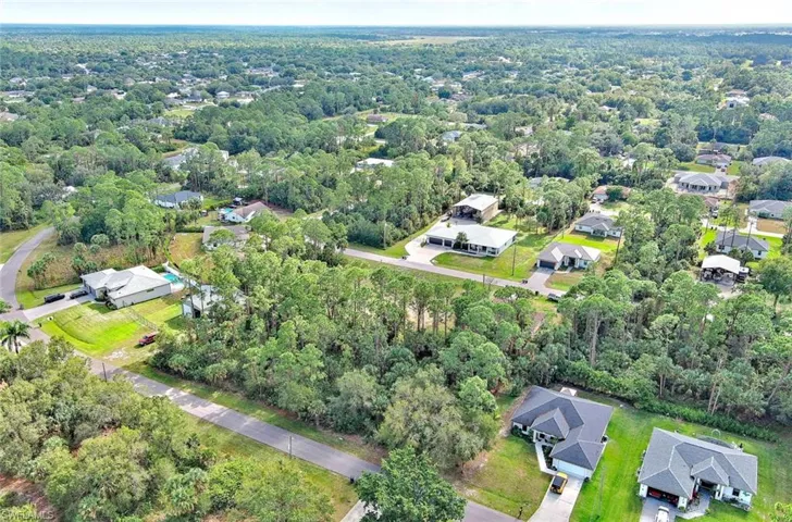 Aerial view of property and surrounding area featuring nearby suburban area