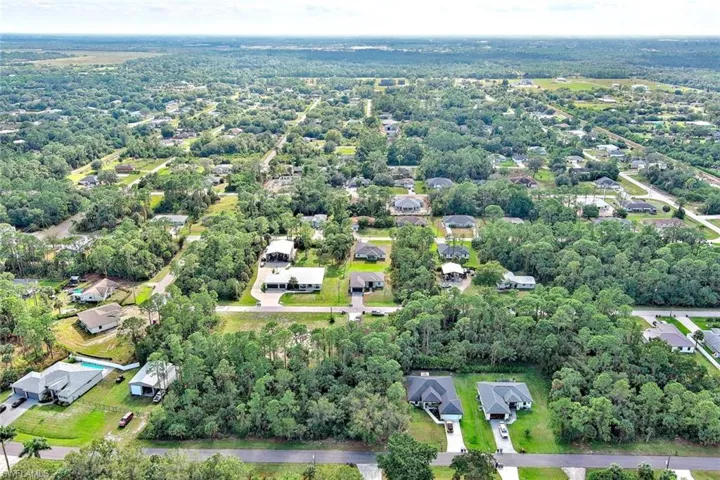 Aerial view of property and surrounding area with nearby suburban area