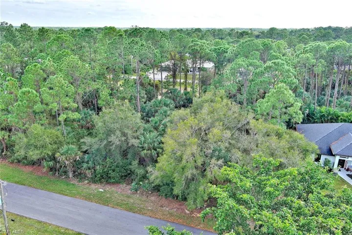 Aerial overview of property's location with a heavily wooded area