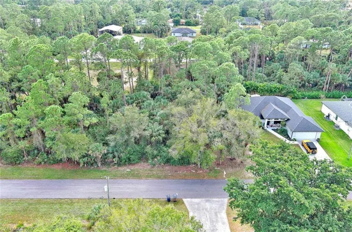 Aerial view of property and surrounding area featuring a forest