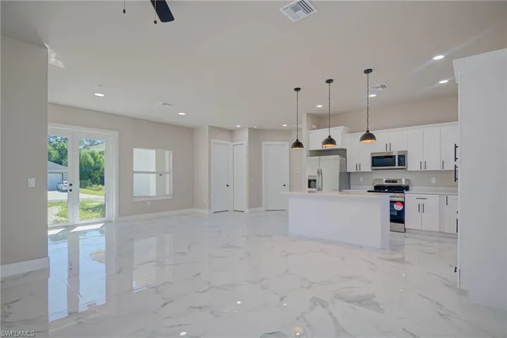 Kitchen featuring marble finish floor, visible vents, appliances with stainless steel finishes, and a kitchen island